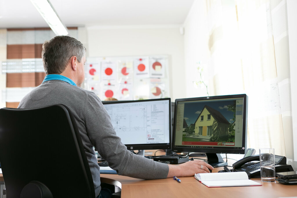 Mann vor zwei Computerbildschirmen